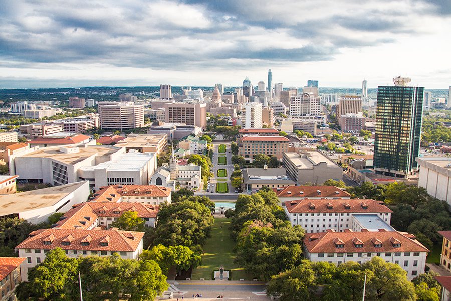Texas Insurance - Aerial View of Downtown Austin Tree-Lined Streets and Tall Buildings With Hills and Clouds in the Distance